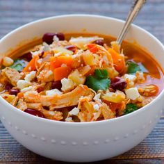 a white bowl filled with soup on top of a wooden table