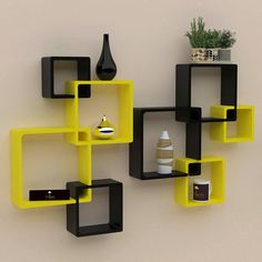 a yellow and black shelf on the wall next to a potted plant in a vase