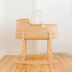 a wooden rocking toy with a basket on it's back in a white room