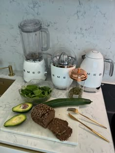 some food is laying out on a cutting board next to an electric blender and knife