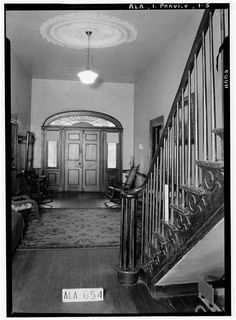 this is an old photo of a house with stairs and a door that leads to another room