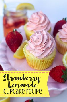 cupcakes with pink frosting and strawberries on a plate next to lemon slices