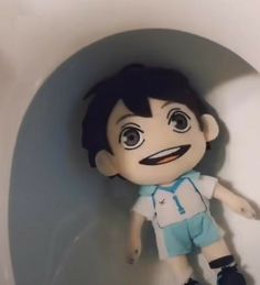 a small doll is sitting in the corner of a toilet bowl with its mouth open