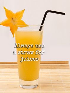 a glass filled with orange juice and a straw