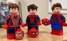 three legos are sitting on a table with spider - man and webman figures