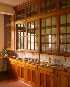 an old fashioned kitchen with wooden cabinets and glass doors