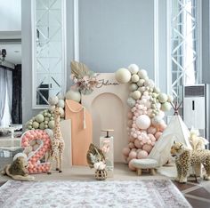 a room filled with lots of balloons and animals on top of a rug in front of a doorway