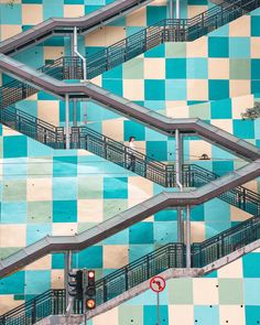 an overhead view of some stairs and railings in a building with checkered tiles on the walls