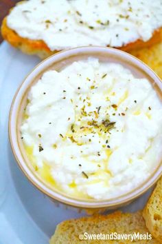 a plate topped with bread slices and a bowl of cream cheese on top of it