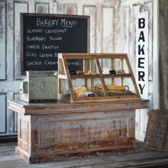 an old fashioned bakery display in front of a chalkboard