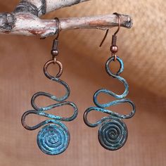 These unique dangle earrings feature copper wires that undergo a meticulous oxidation process, giving them their splendid aqua hue. Expertly handcrafted by artisan Arman Badeyan, they showcase a stunning spiral and swirl design complemented by brass hooks. Inspired by the vibrant artistry of Armenian culture, these accessories are a must-have for those who appreciate exquisite craftsmanship and distinctive style. Bohemian Spiral Copper Earrings, Bohemian Copper Spiral Earrings, Bohemian Spiral Copper Wire Earrings, Calder Jewelry, Wrapping Crystals, Wig Jig, Copper Wire Crafts, Unique Dangle Earrings, Armenian Culture