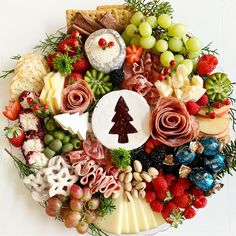 a platter filled with different types of cheeses, fruit and crackers in the shape of a christmas tree