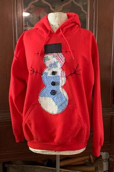 a red hoodie with a snowman on the front and blue number six on the back