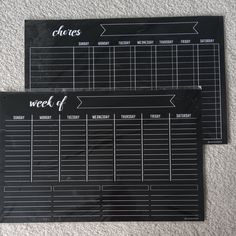 two black and white calendars sitting on top of a carpeted floor next to each other