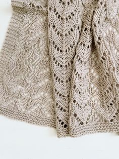 a knitted shawl draped over a white surface