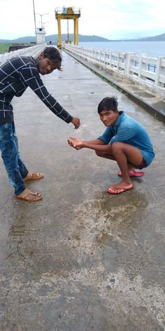 two people standing on the side of a road touching their hands with another person's hand