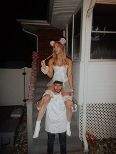 a man and woman dressed up as mice on the front steps of a house at night