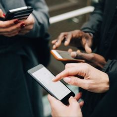 three people holding cell phones in their hands