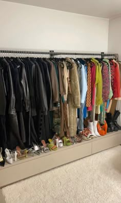 an organized closet with many coats and shoes