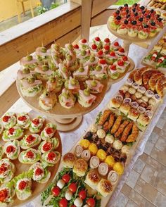 a table topped with lots of different types of food on top of wooden trays