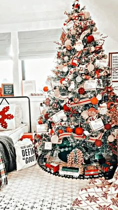 a decorated christmas tree in a living room with red and white ornaments on the top