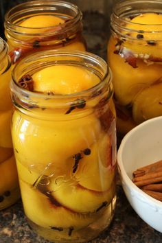 several jars filled with apples and cinnamon sticks