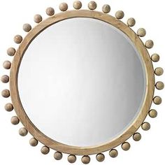 a round wooden mirror with balls around it