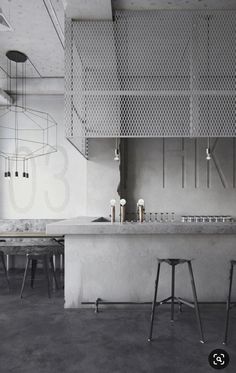 an empty room with two stools in front of the counter and several chairs on the floor