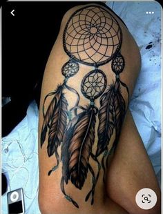 an image of a woman's thigh with tattoos on it and a dream catcher tattoo