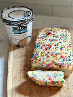 a loaf of cake with sprinkles next to a cup of ice cream