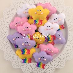 a white plate topped with lots of colorfully decorated sugar cookies on top of a doily