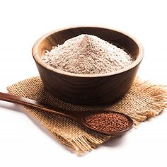 a wooden bowl filled with powder next to a spoon