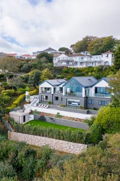 A drone view of a house on a sloped site in guersney with staggered garden Upside Down House, Fort George, St Peter, Coastal Home, Aluminium Doors, Sash Windows