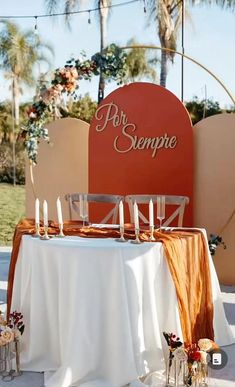 an orange and white table with candles on it next to a sign that says por sempie