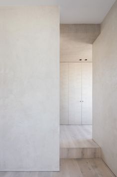 an empty room with white walls and wooden flooring is seen from the entrance way