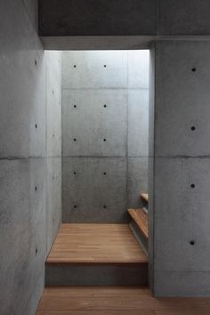 a wooden bench sitting inside of a cement building