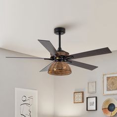 a ceiling fan in a room with pictures on the wall