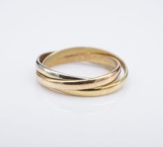 three gold wedding bands stacked on top of each other, with one ring in the middle