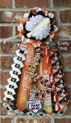 an orange and black christmas tree hanging on a brick wall with the words crafty bug above it