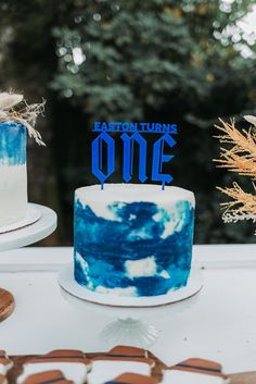 a blue and white cake sitting on top of a table