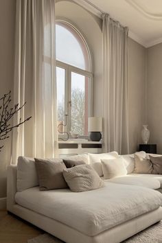 a large white couch sitting in front of a window