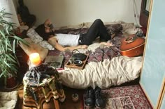 a man laying on top of a bed next to a plant