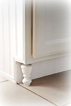 a white cabinet sitting in the corner of a kitchen next to a floor tile pattern