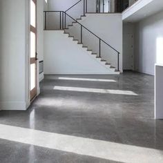 an empty room with stairs leading to the second floor and another open space on the other side