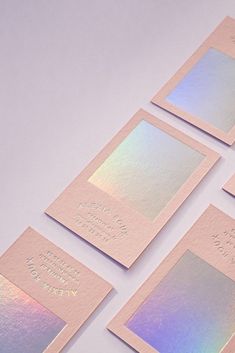 four pink and blue cards with metallic foil on them