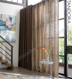 a living room filled with furniture next to a window covered in brown drapes and curtains