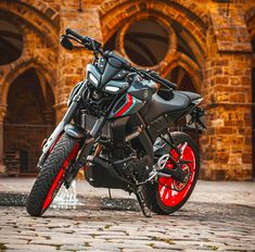 a black and red motorcycle parked in front of a building