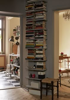 a book shelf filled with lots of books in a living room next to a dining room table