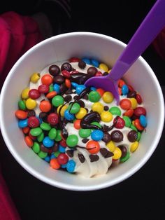 a bowl filled with ice cream and lots of candy