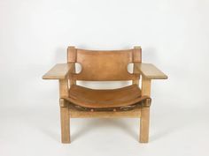 a brown leather chair sitting on top of a white floor